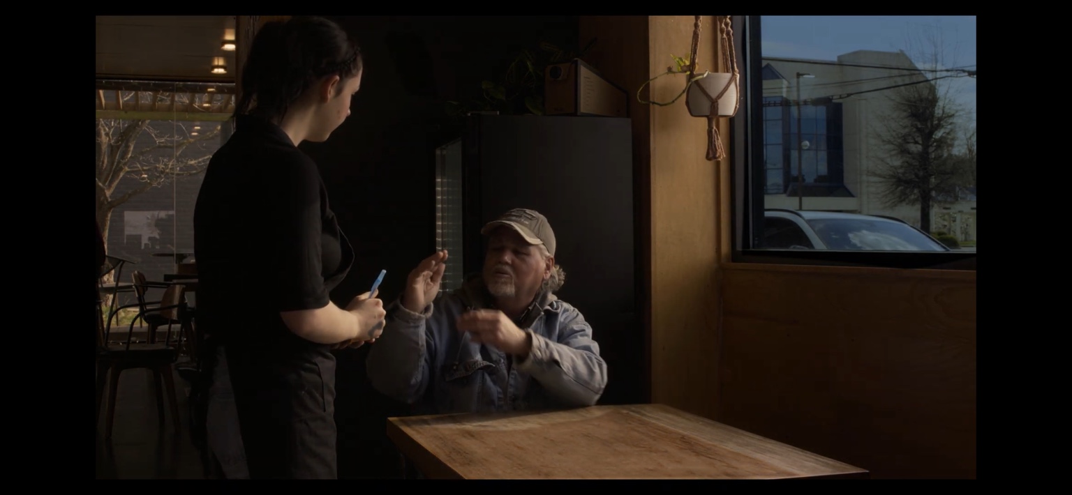 Two characters share a moment in The Coffee Shop.